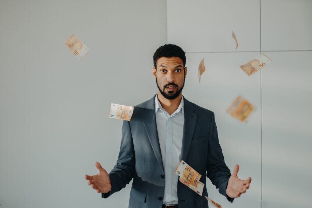 man standing with money flying all around