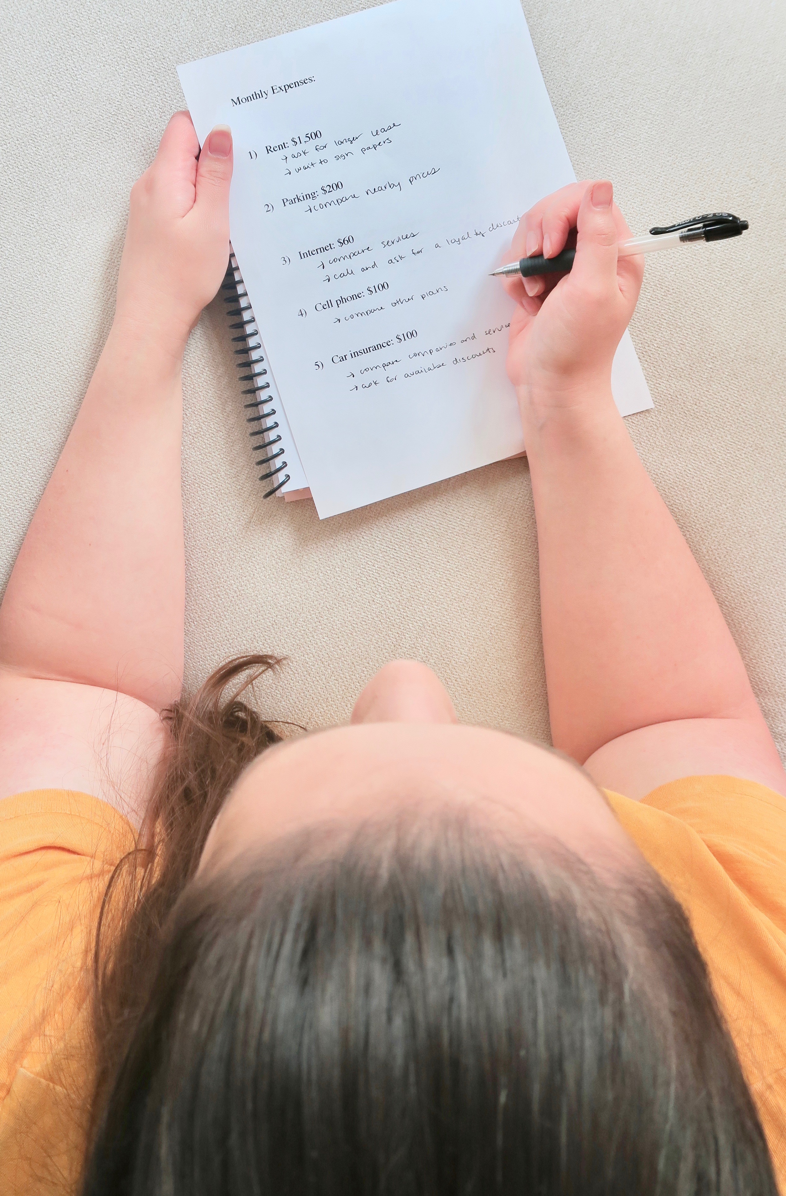 girl writing list of monthly expenses