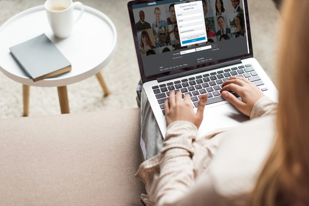 how to introduce people on linked in (10 easy templates included) blonde woman typing on a computer with linkedin login screen open