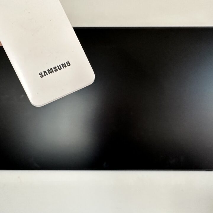 picture of a samsung remote in front of a samsung frame tv