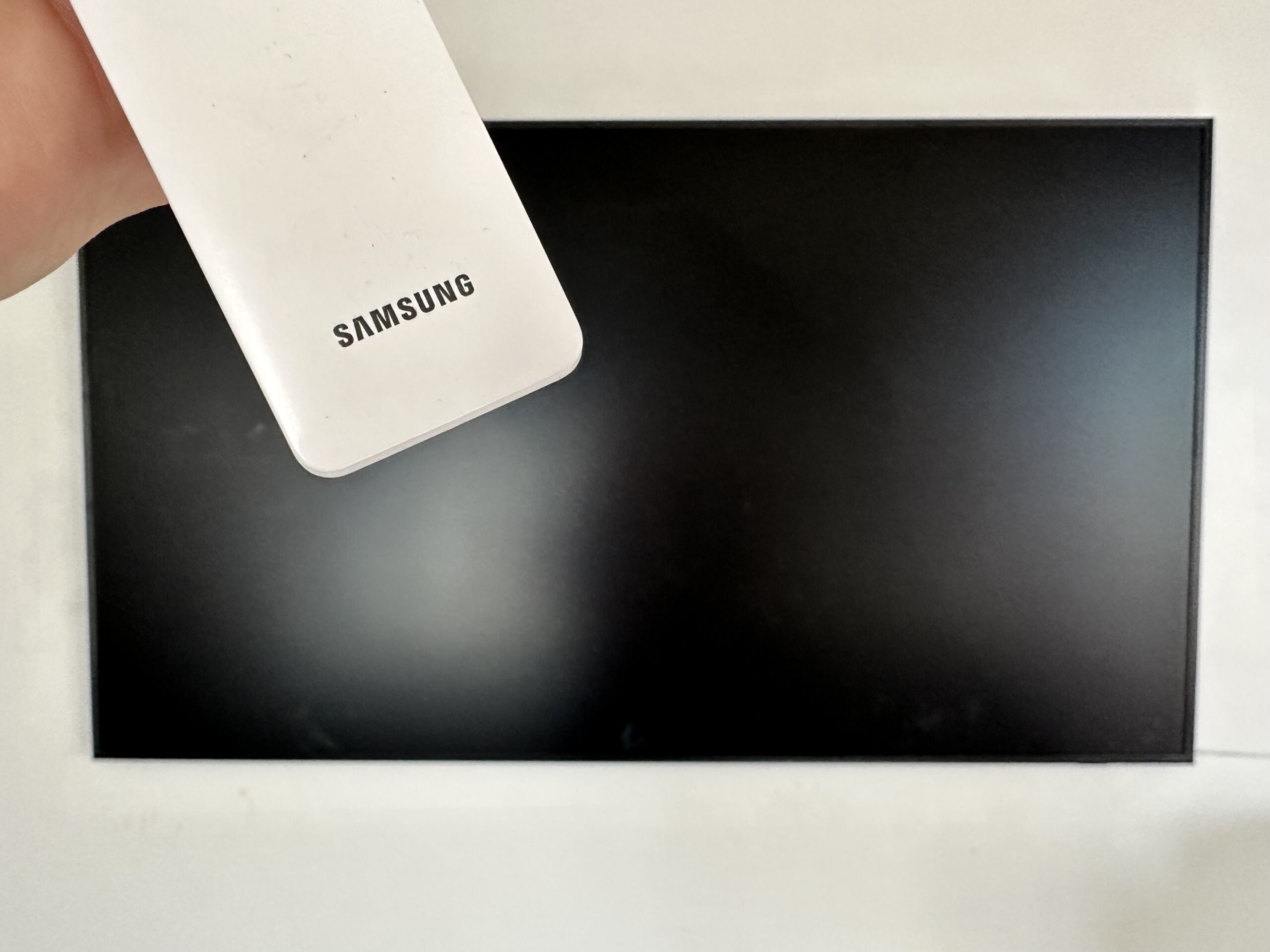picture of a samsung remote in front of a samsung frame tv