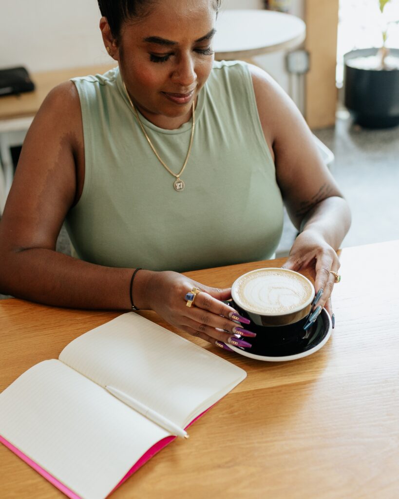 black woman with coffee and a notebook