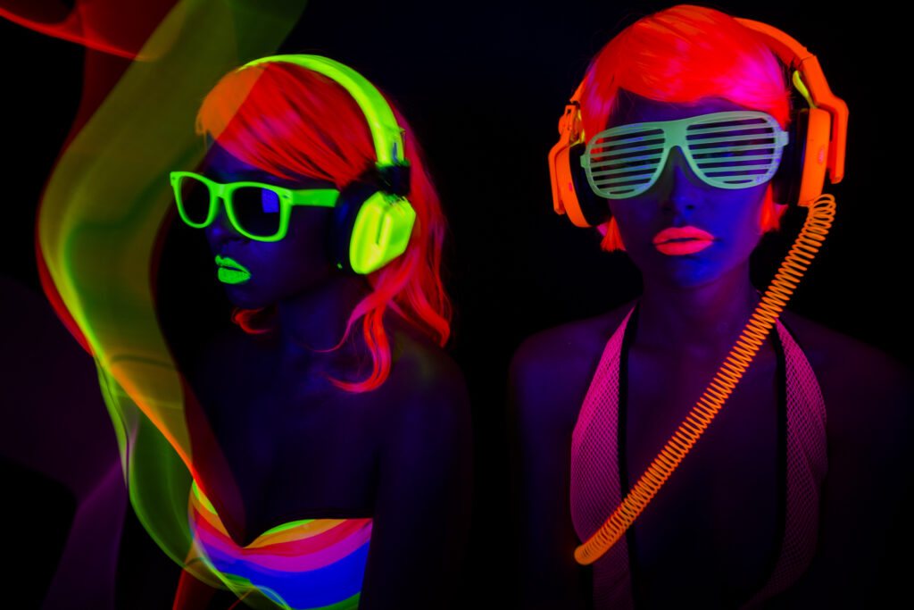 two female disco dancers posing in UV costume