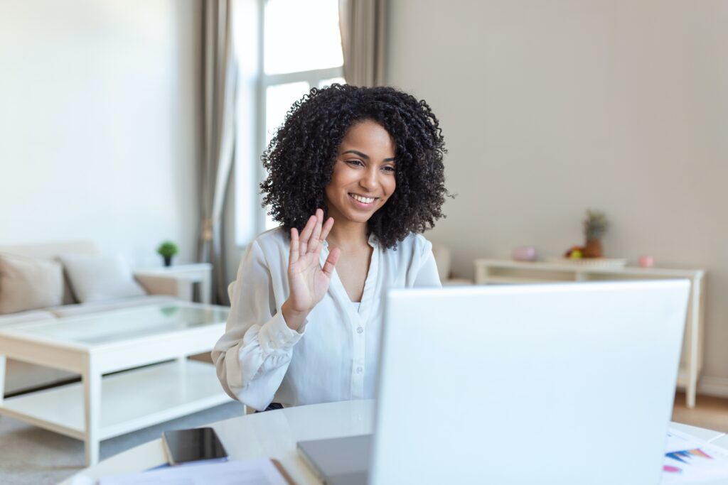 woman waving at computer