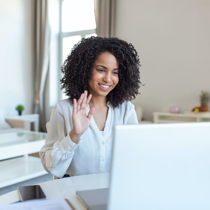 woman waving at computer