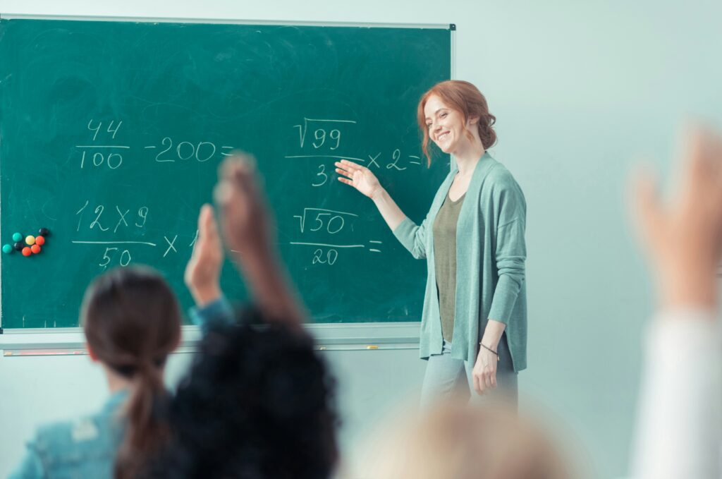 young woman teaching in front of blackboard