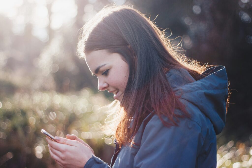 a woman staring at phone with fascination