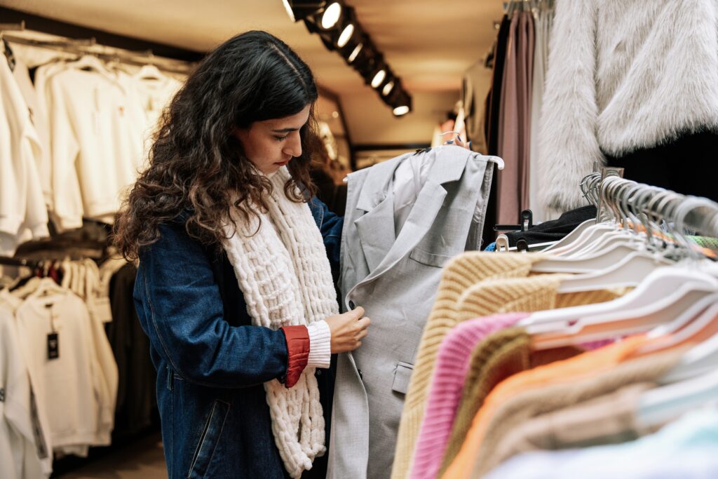 a young woman tries to decide to buy a garment or not