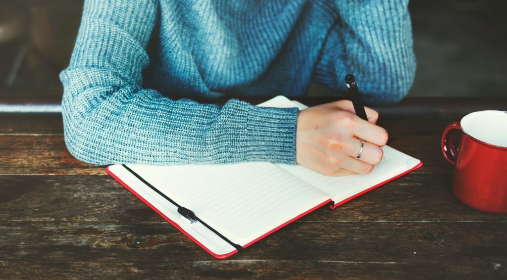 woman writing in a journal to start off her day