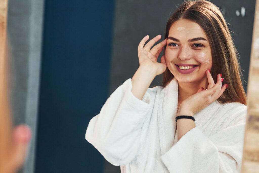young woman applies product to her skin in the mornings