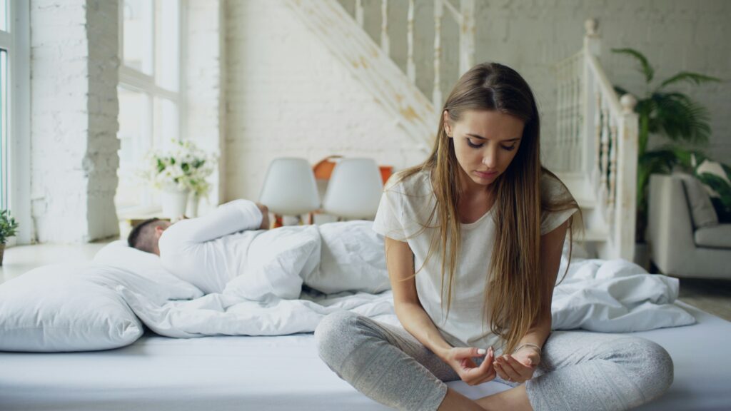 a sad young woman sits separate from her partner