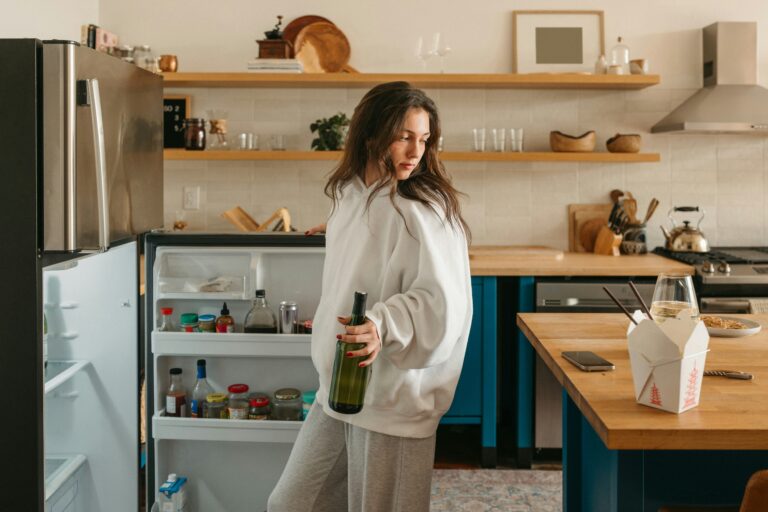 young woman cleaning out her fridge