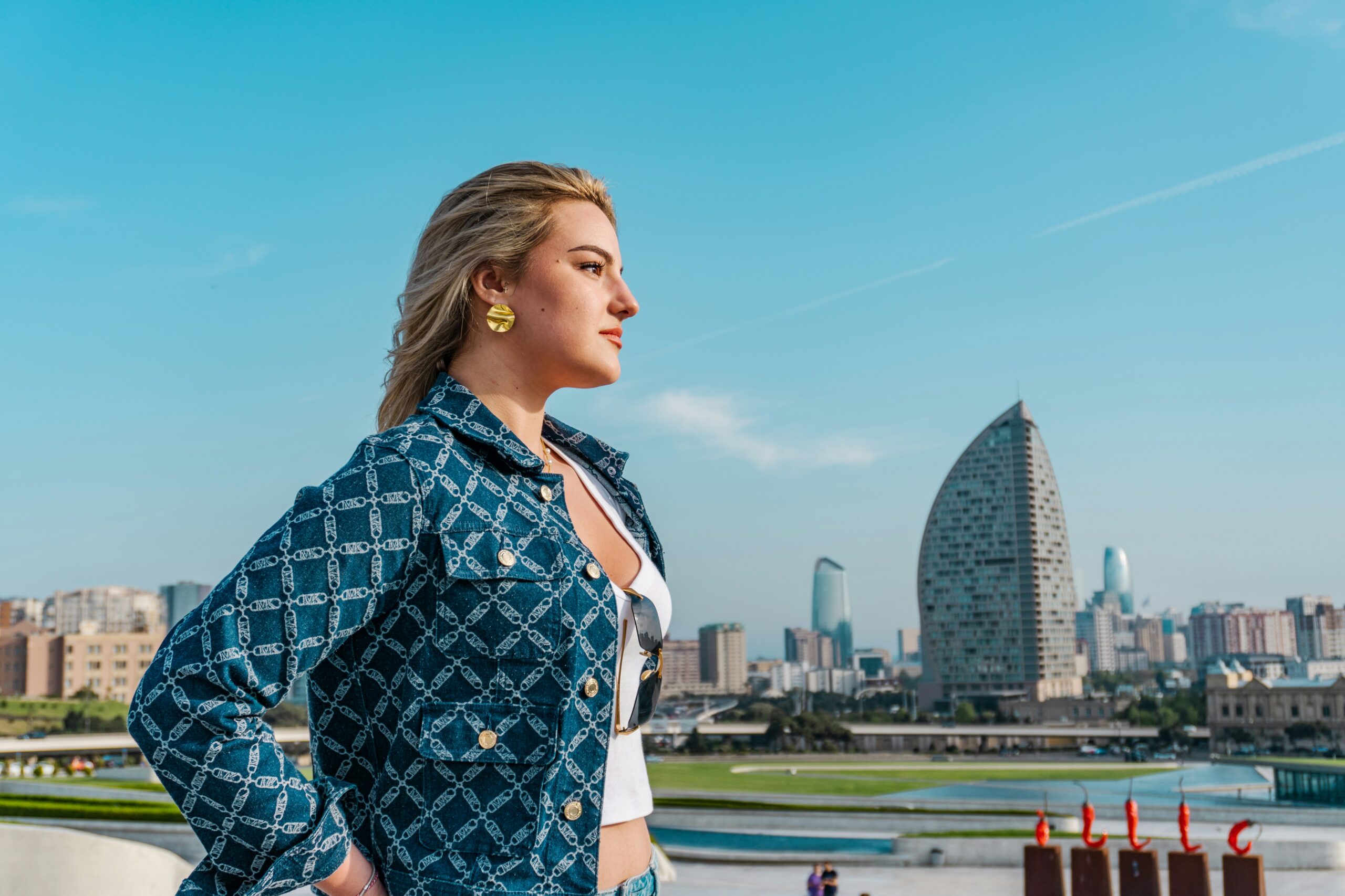 confident young woman stands tall with a city background