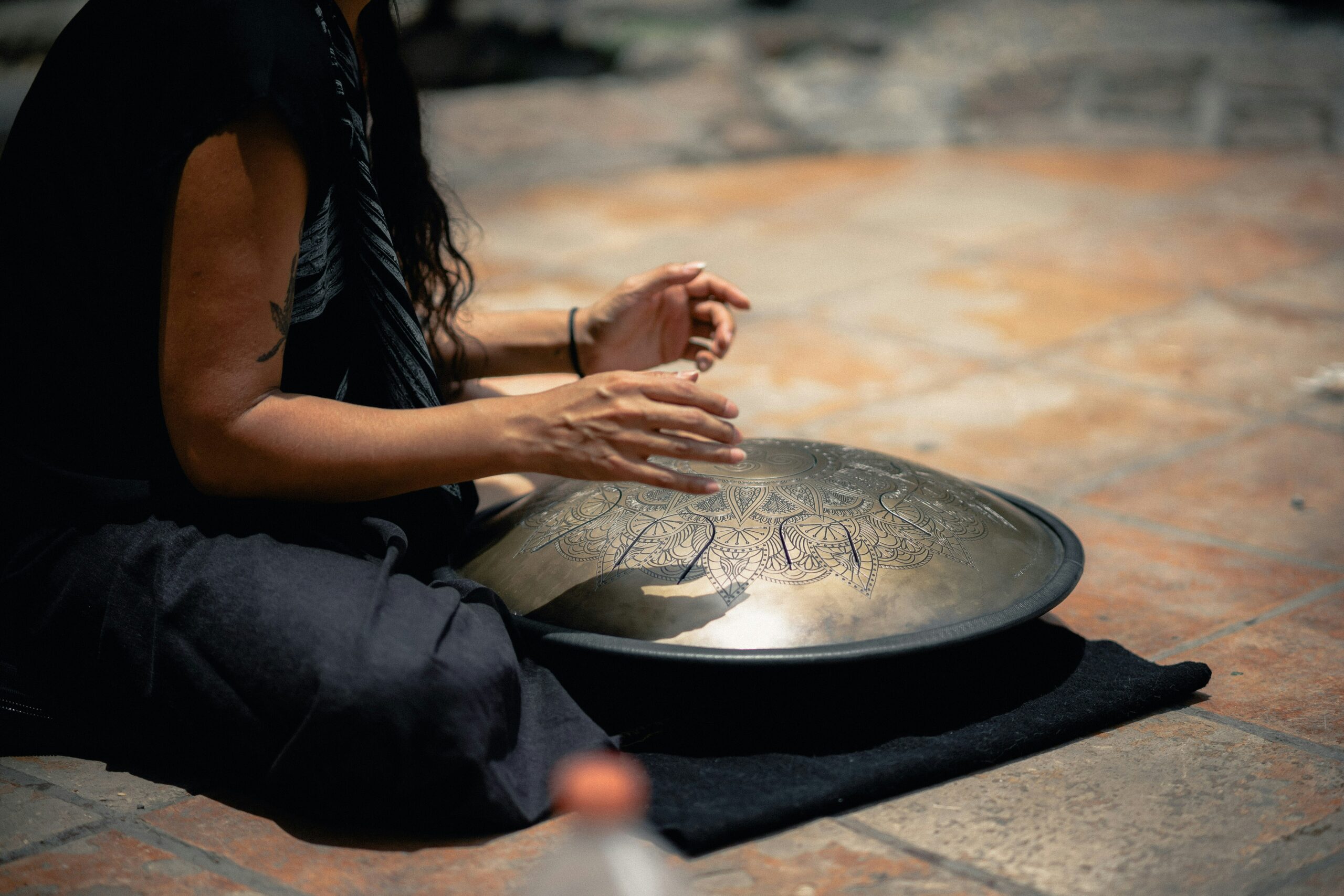 woman plays the steel tongue drum