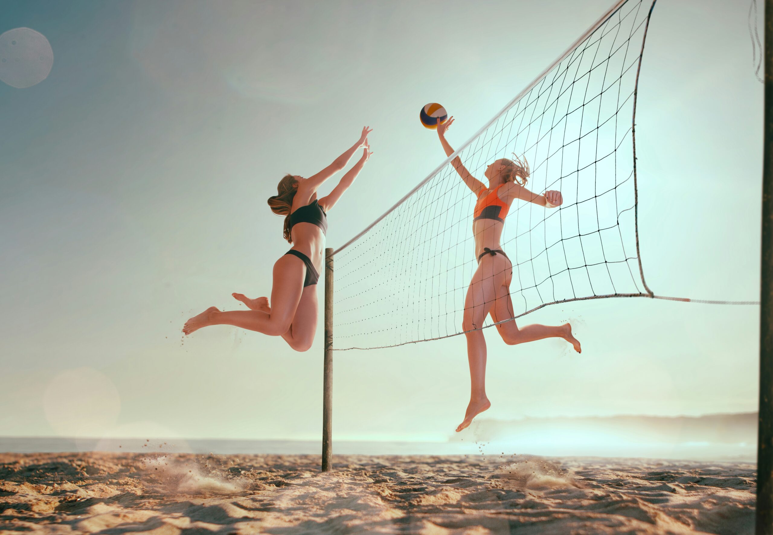 two women playing beach volleyball