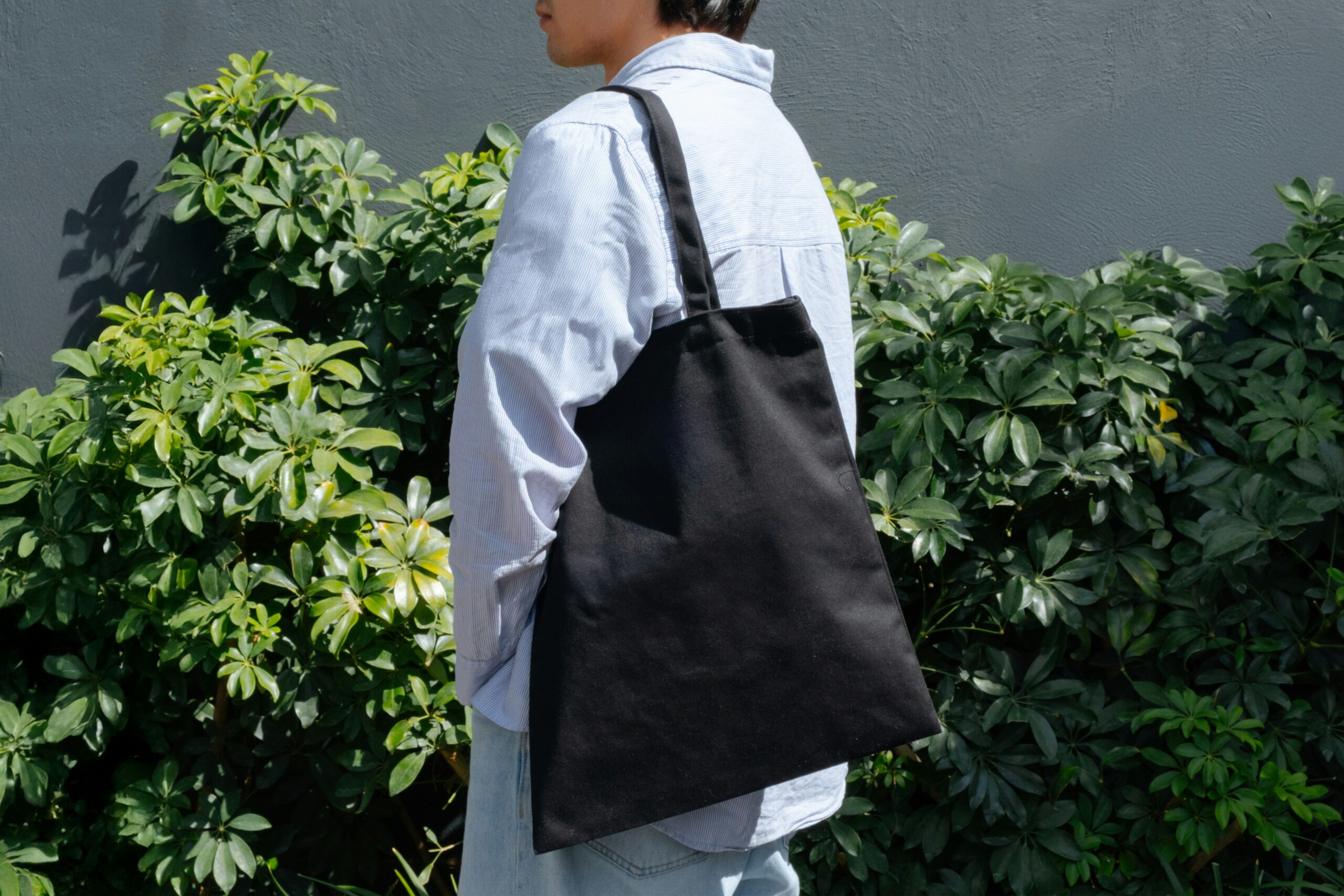 man carrying a black tote bag