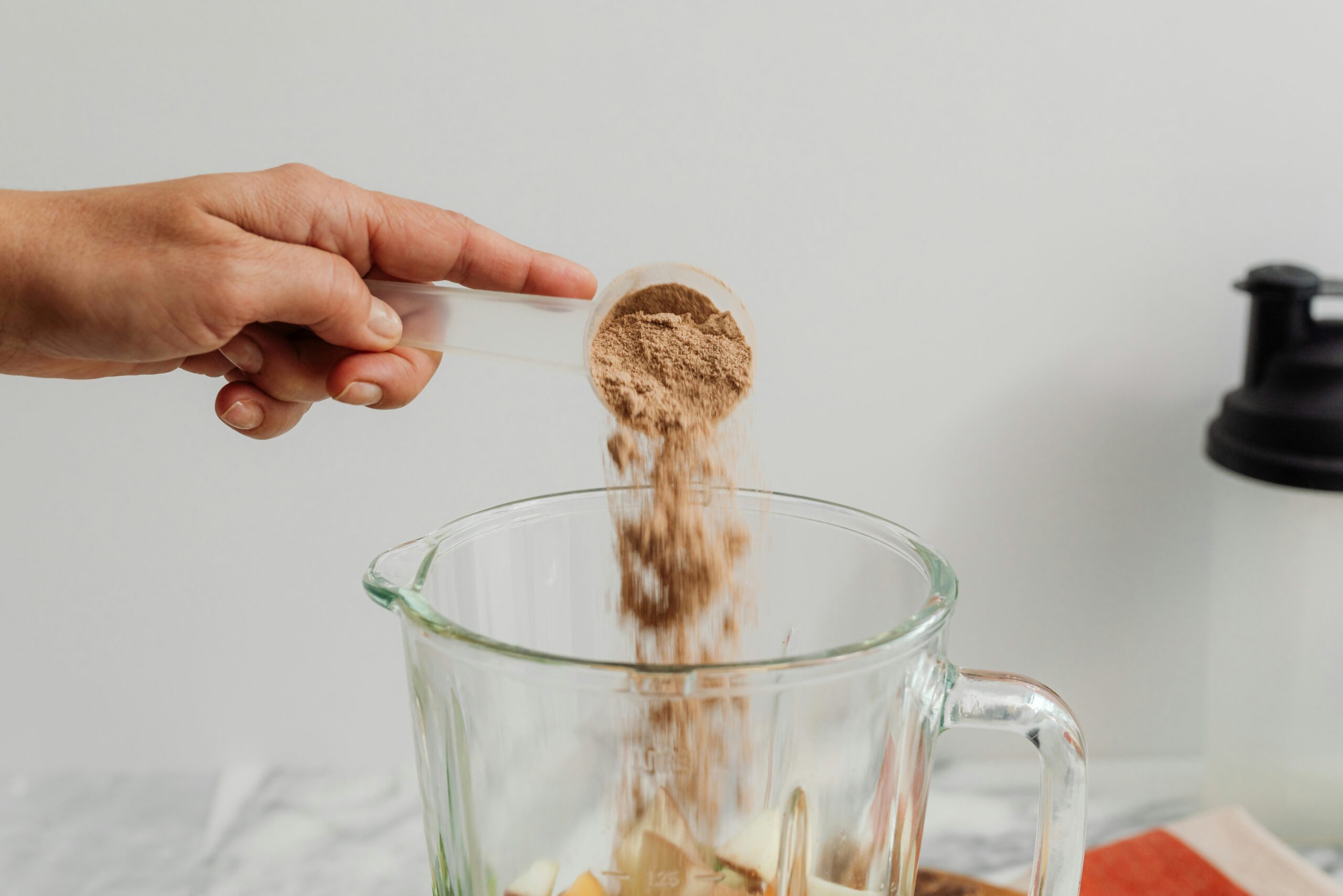 putting protein powder in a blender
